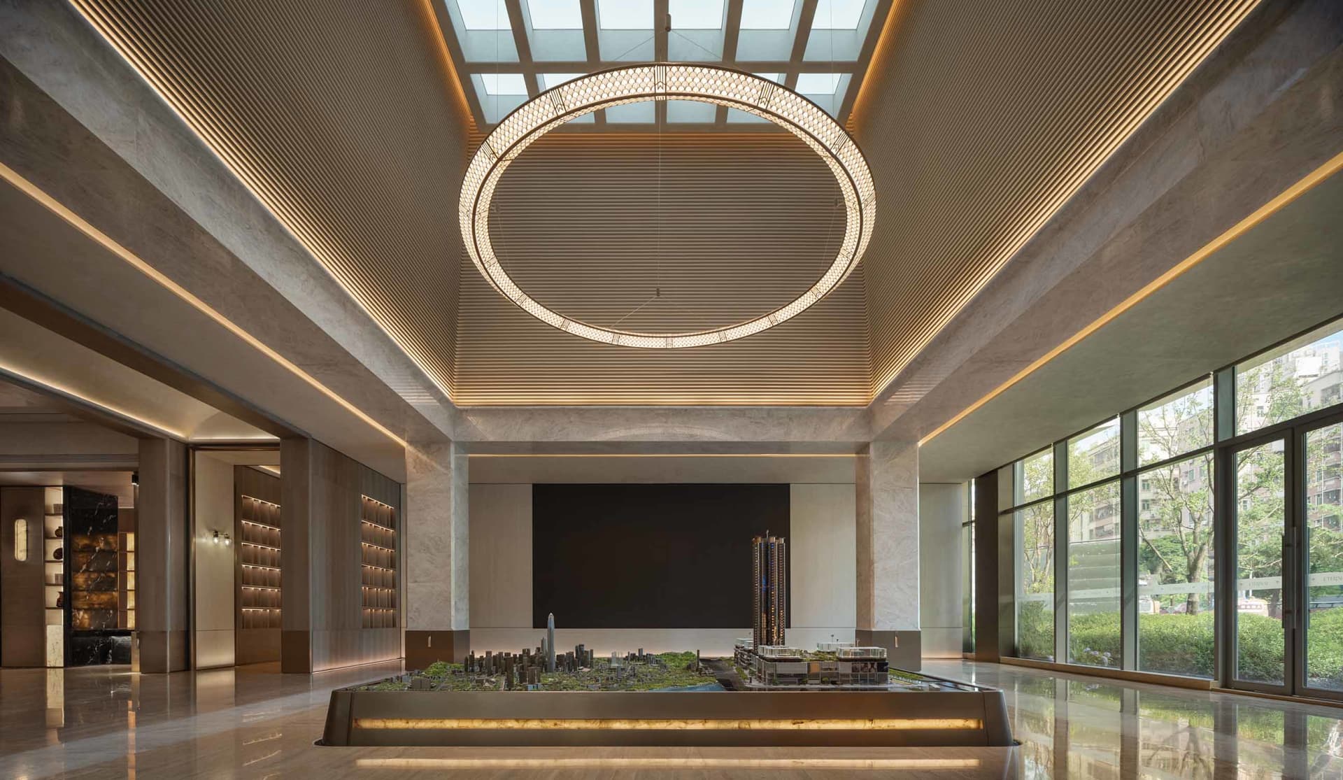 A large, open room with a high ceiling, featuring a detailed city model on a table, in a bright and even lit modern architectural setting