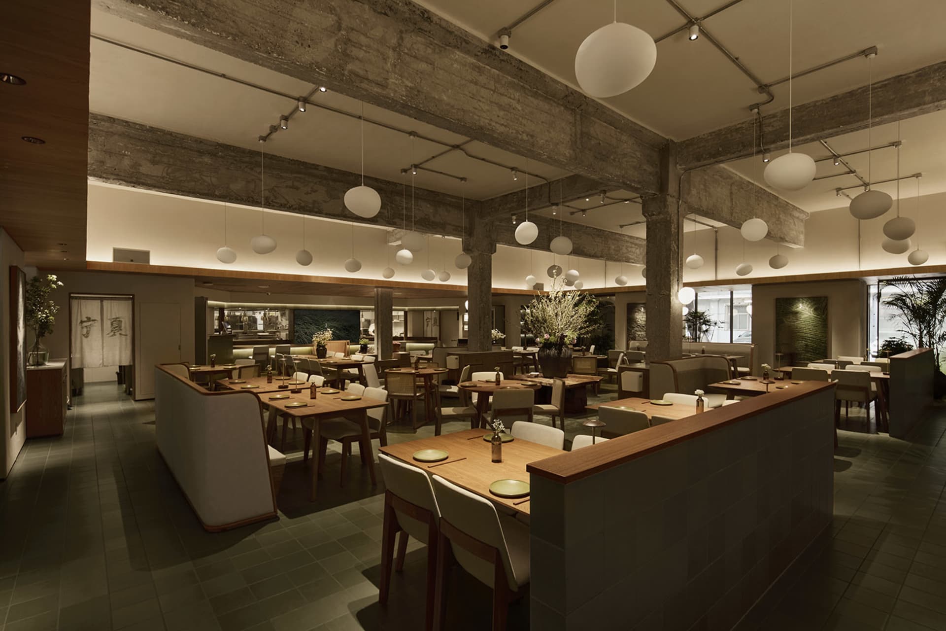 Spacious modern Japanese restaurant interior featuring exposed concrete ceiling beams, numerous spherical pendant lights, wooden dining tables, and upholstered seating arranged in multiple zones.