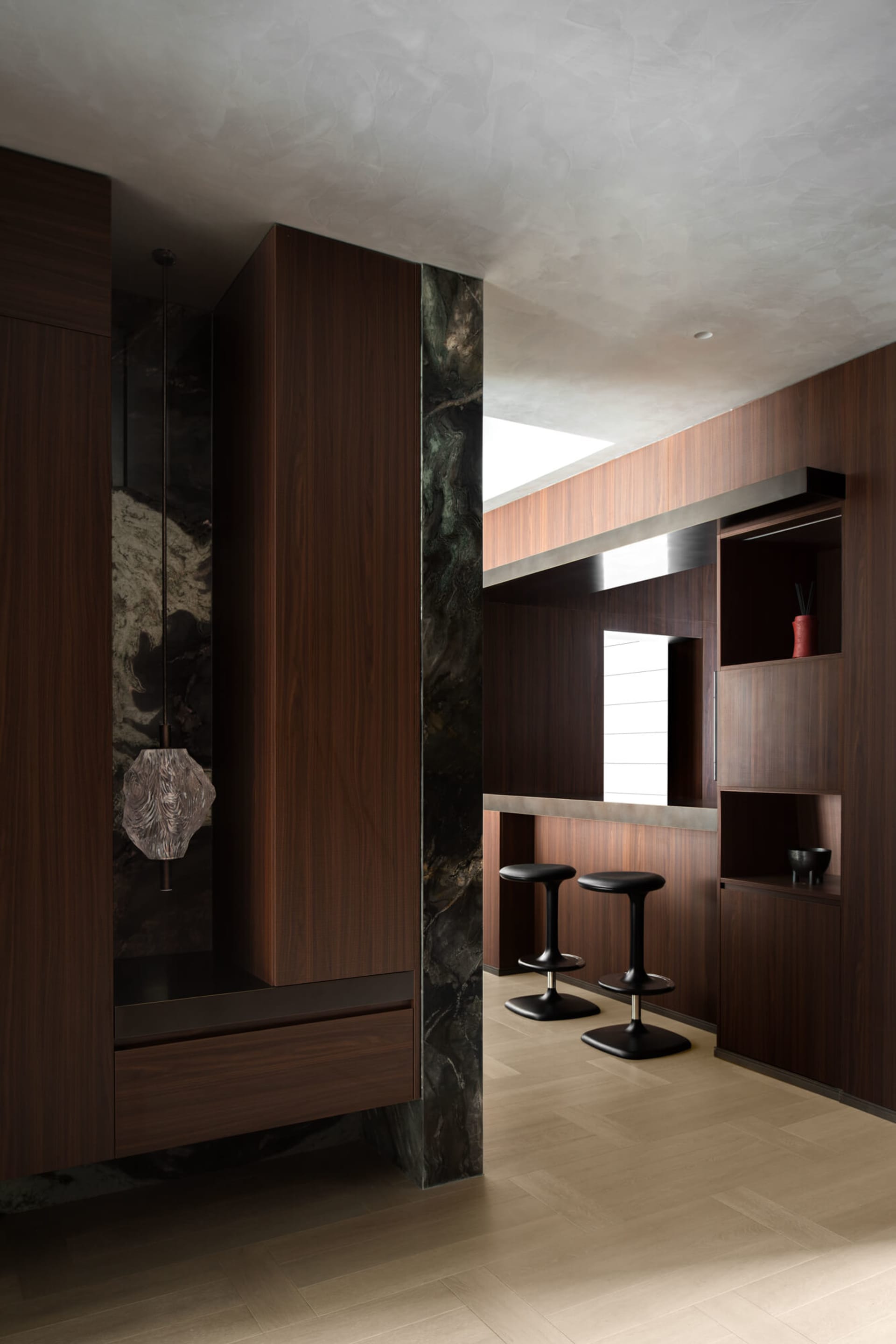 A sophisticated built-in bar area featuring rich walnut cabinetry and ...