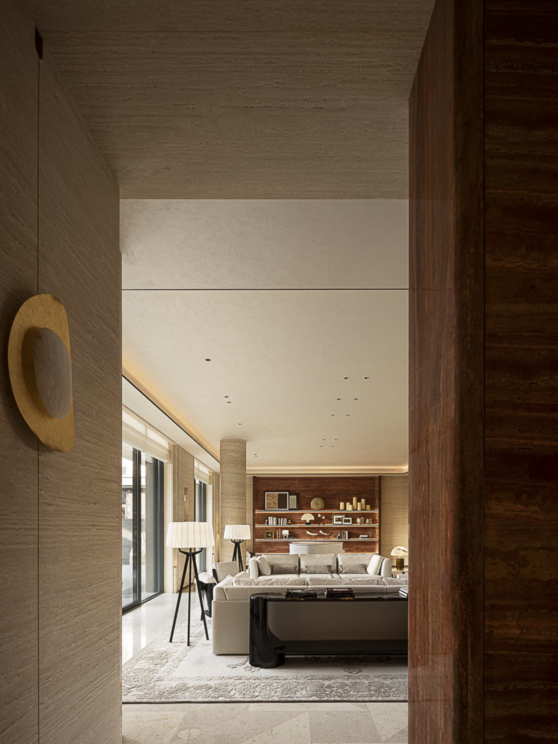 Modern luxury living room featuring travertine walls, a large cream sectional sofa, dark wood bookshelf, and layered lighting.
