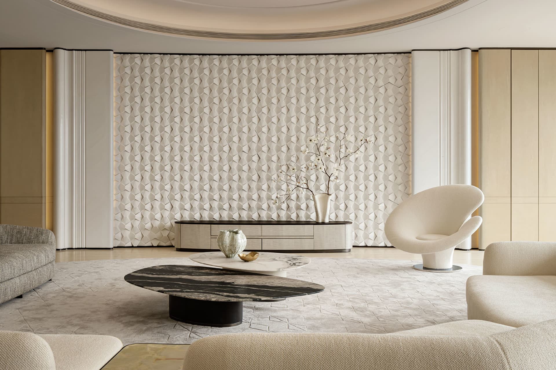 Modern luxury living room featuring a large curved white textured plaster accent wall, cream boucle swivel chairs, marble coffee tables, and soft neutral furnishings under a dramatic curved ceiling.