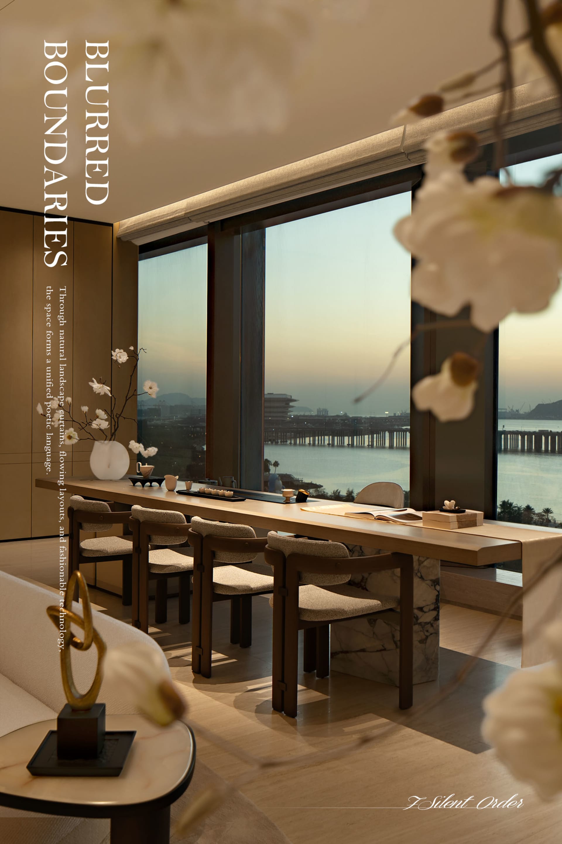 Modern dining area featuring a long walnut table with upholstered chairs, marble base, set against floor-to-ceiling windows overlooking a harbor and mountains at dusk.