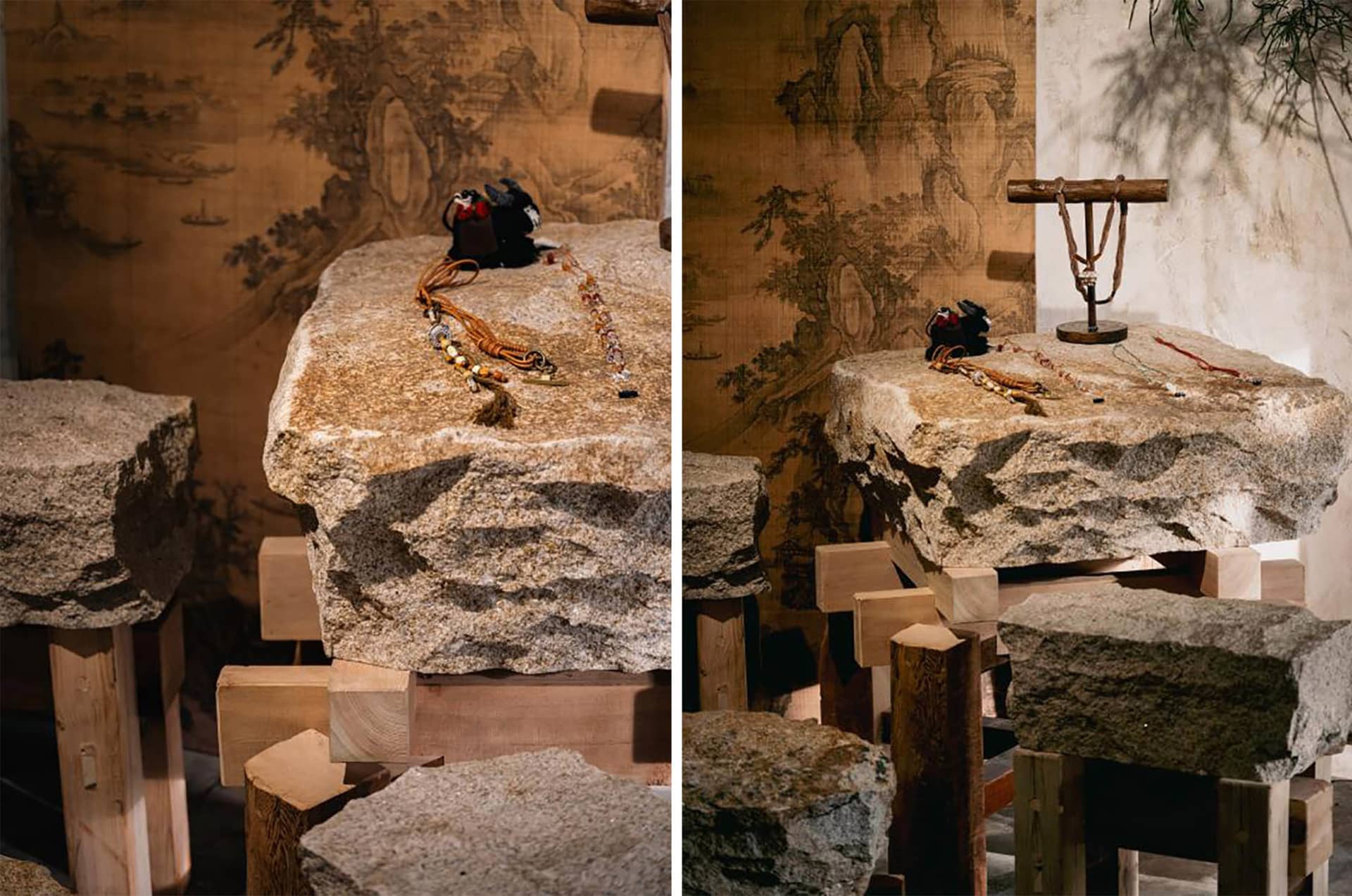 Two views of a rustic jewelry display made from large irregular natural stone slabs supported by wooden blocks, with traditional Chinese ink landscape paintings in the background and various necklaces and ornaments arranged on top.