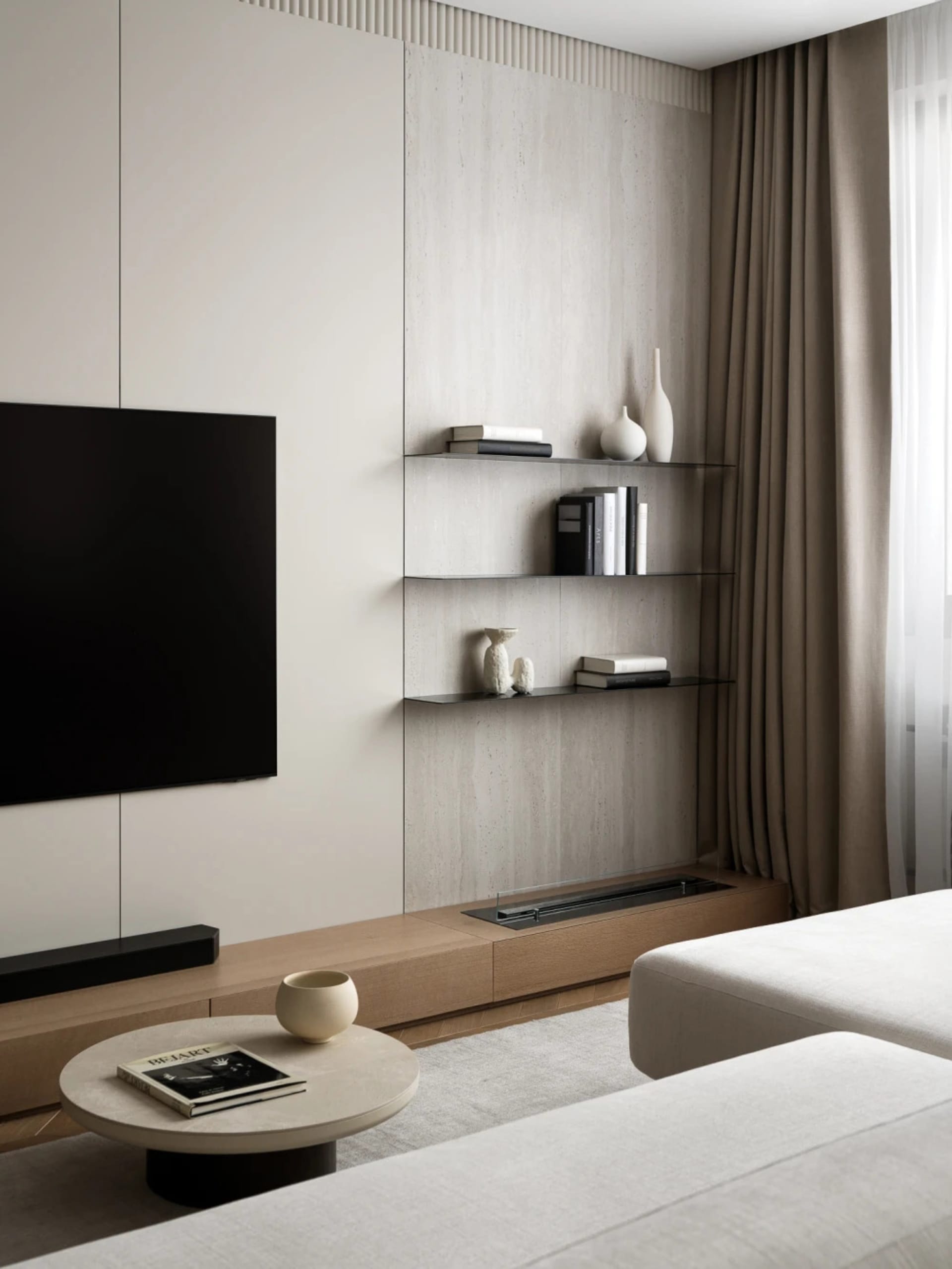Modern minimalist living room featuring a wall-mounted TV, light oak media console, floating glass shelves with decor, and neutral-toned sofa with round coffee table.