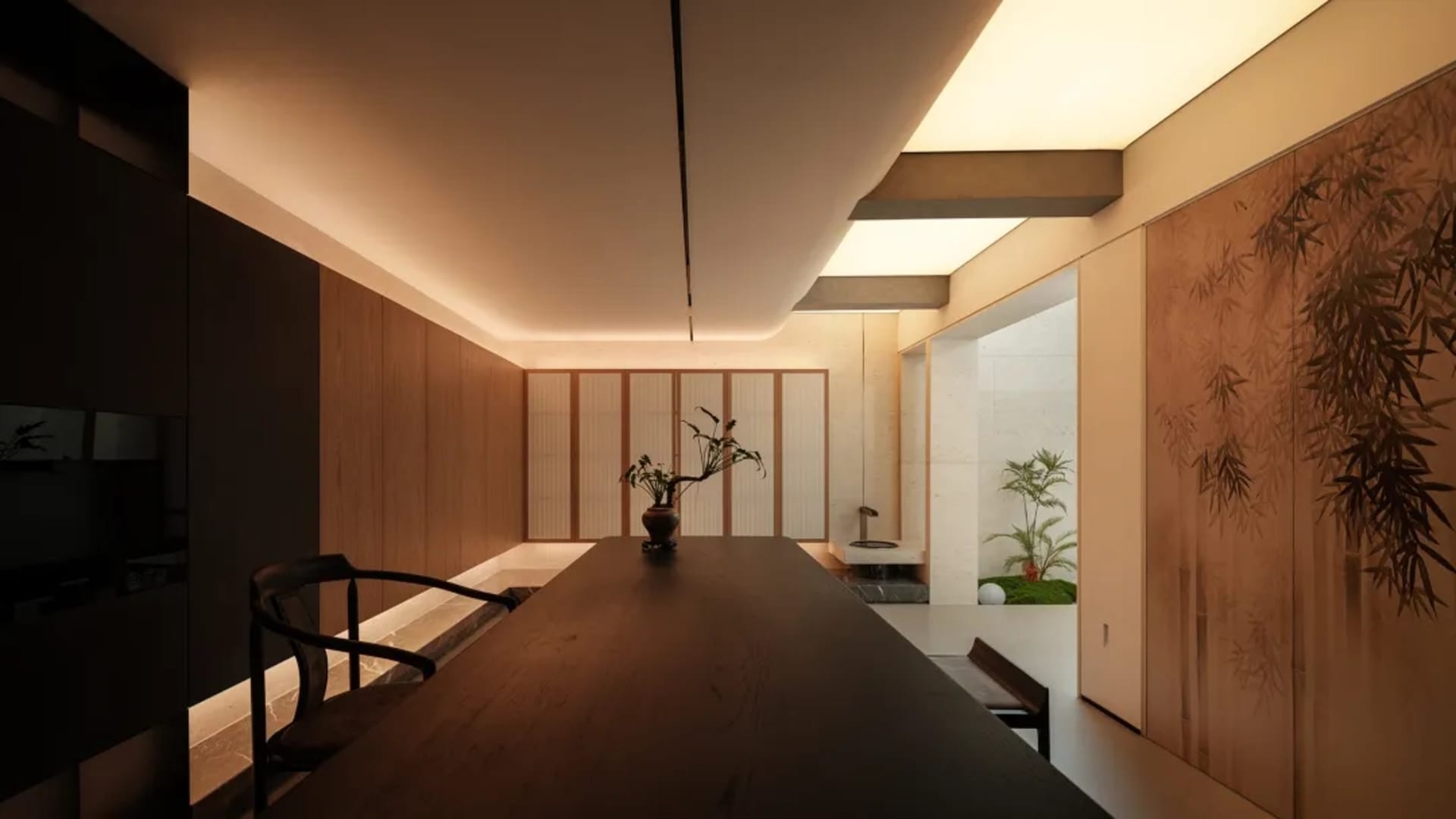 Modern minimalist dining room featuring a long dark walnut wood table, a black wooden chair, warm cove lighting, and large sliding doors with traditional bamboo paintings opening to a small zen garden.