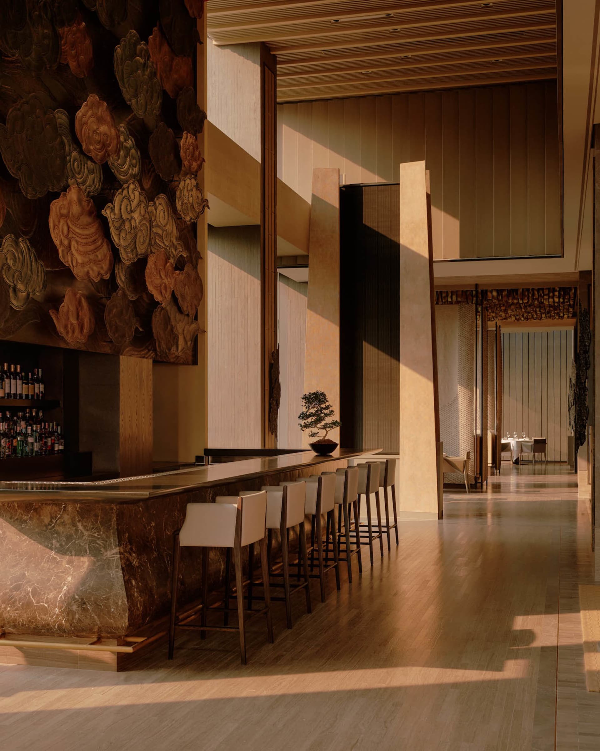 Luxurious long marble bar with white leather bar stools in a high-end lounge featuring a massive traditional Chinese cloud pattern wall carving and warm ambient lighting.