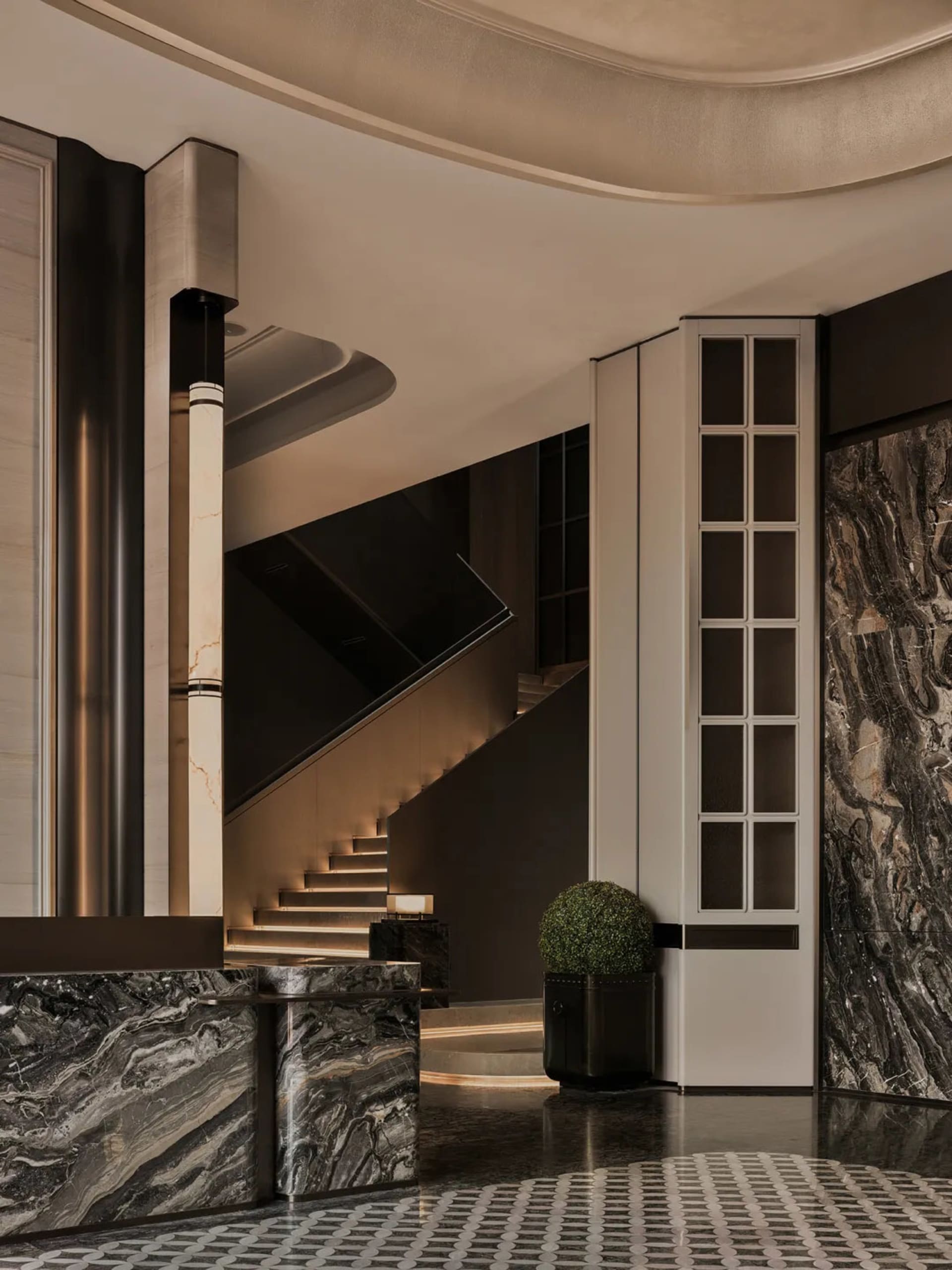 Modern luxury lobby featuring a grand floating marble staircase with integrated LED lighting, dark veined marble reception desk, patterned tile floor, and a potted topiary beside a tall grid window.