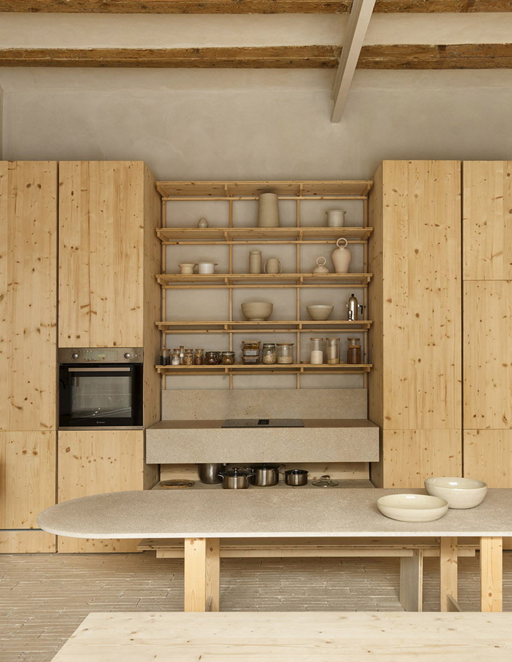 Modern minimalist kitchen with built-in cabinets, concrete counter, and warm wood storage.
