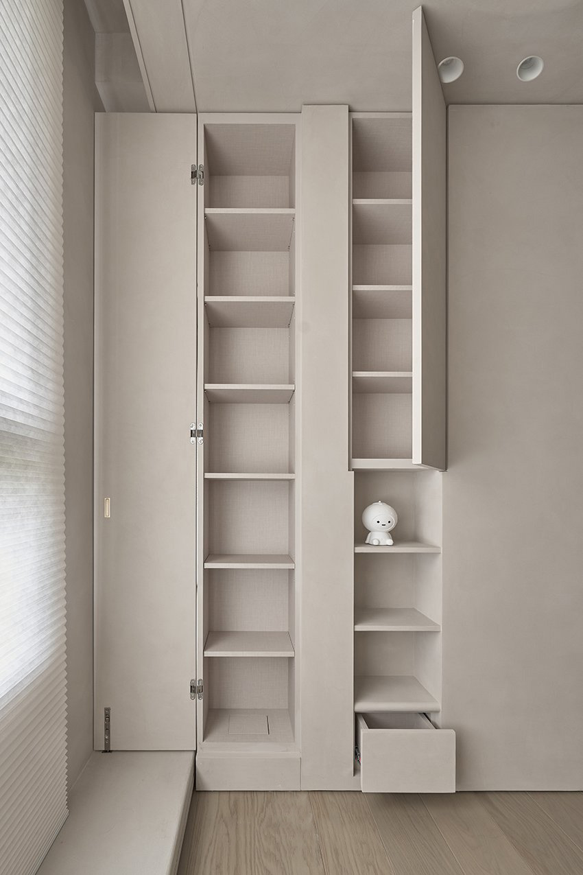 Minimalist closet storage with neutral wood shelving arranged along multiple walls for maximum capacity.