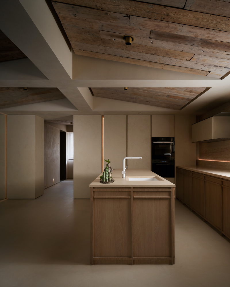 Minimalist kitchen with open wood shelving instead of upper cabinets — demonstrating how removing one wall of uppers opens up a narrow galley