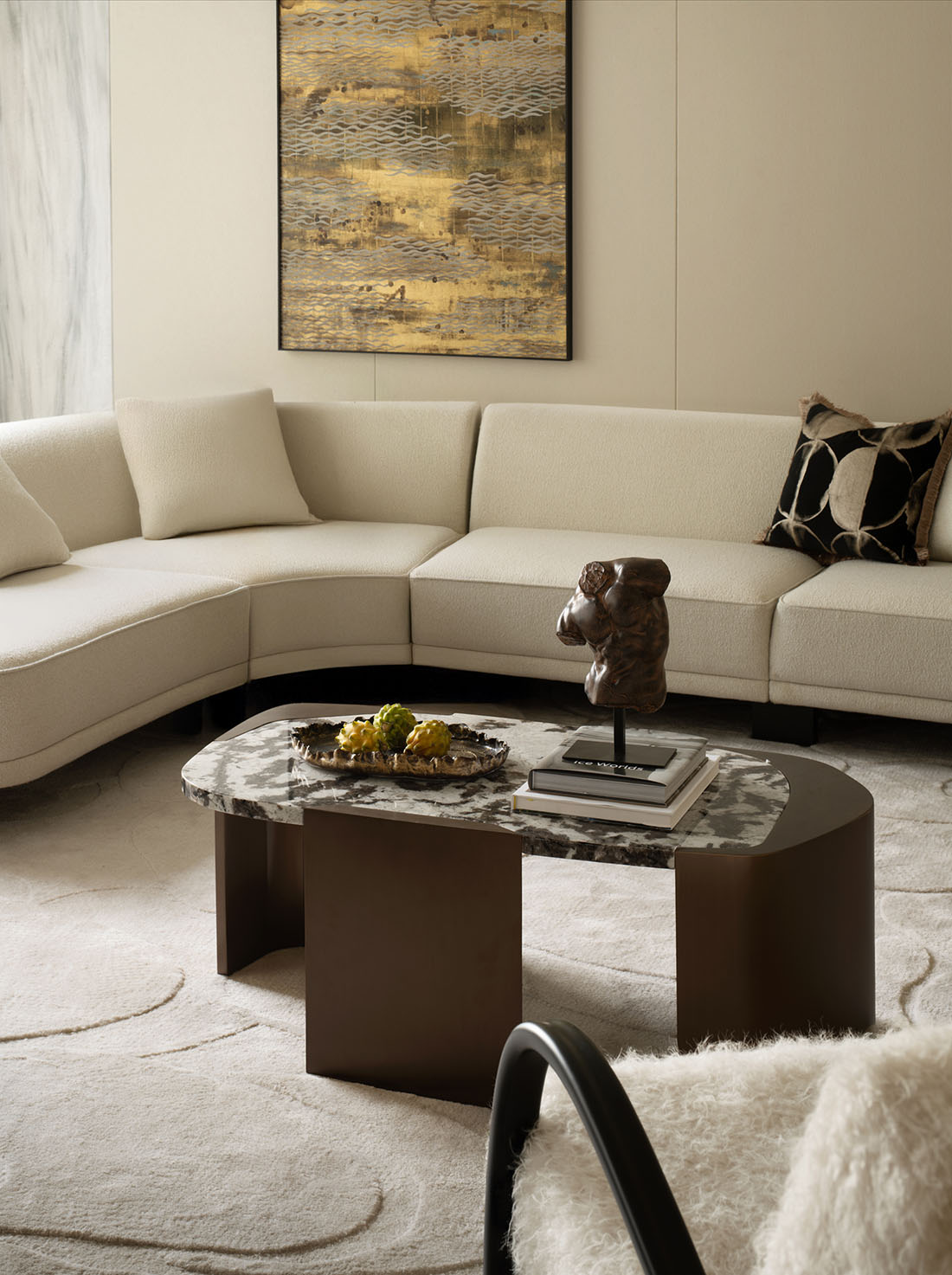 Warm modern interior with cream sofa, marble side table, and walnut floor — earthy neutral tones throughout.