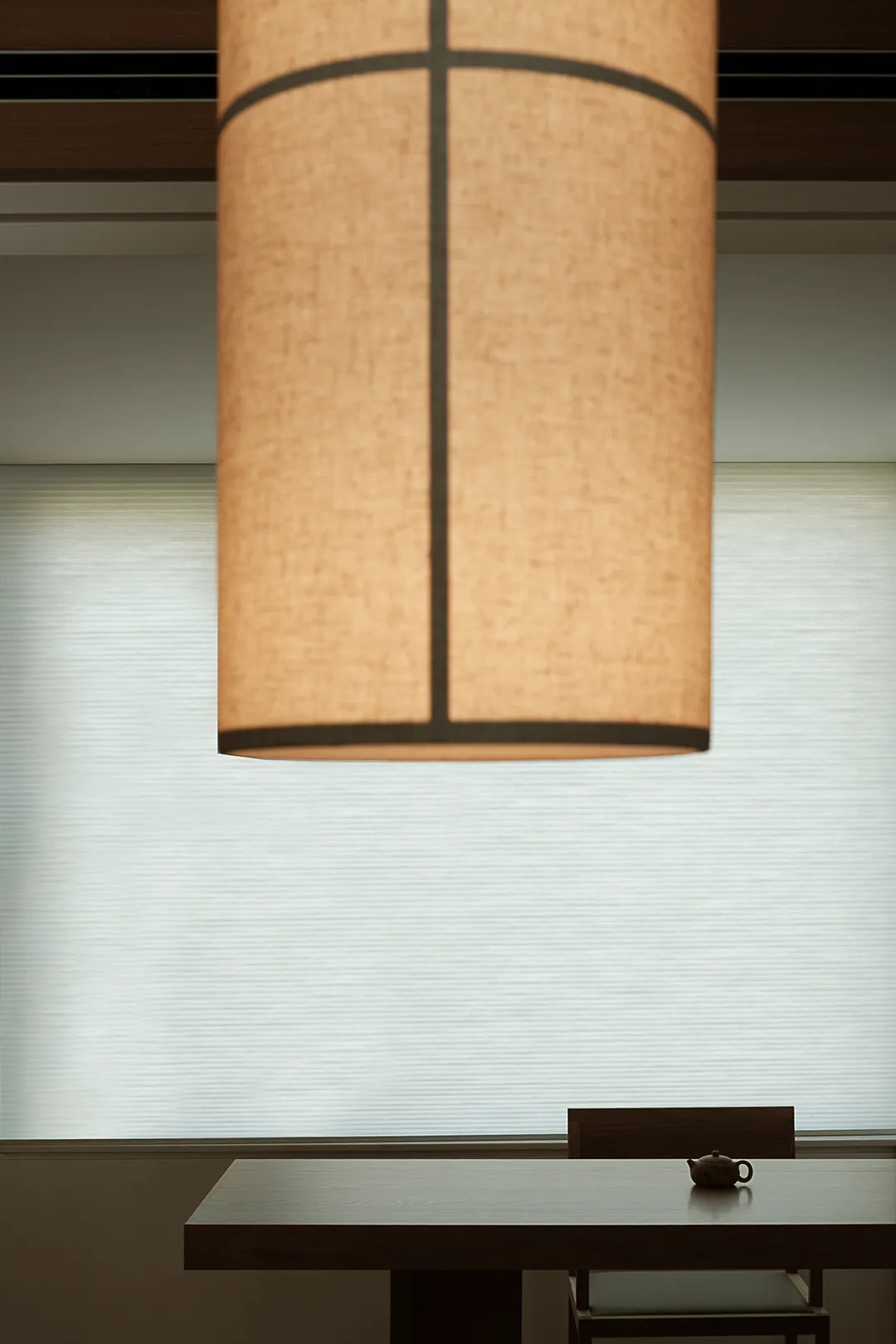 Warm minimalist living room with fabric seating, an area rug, and layered lighting.