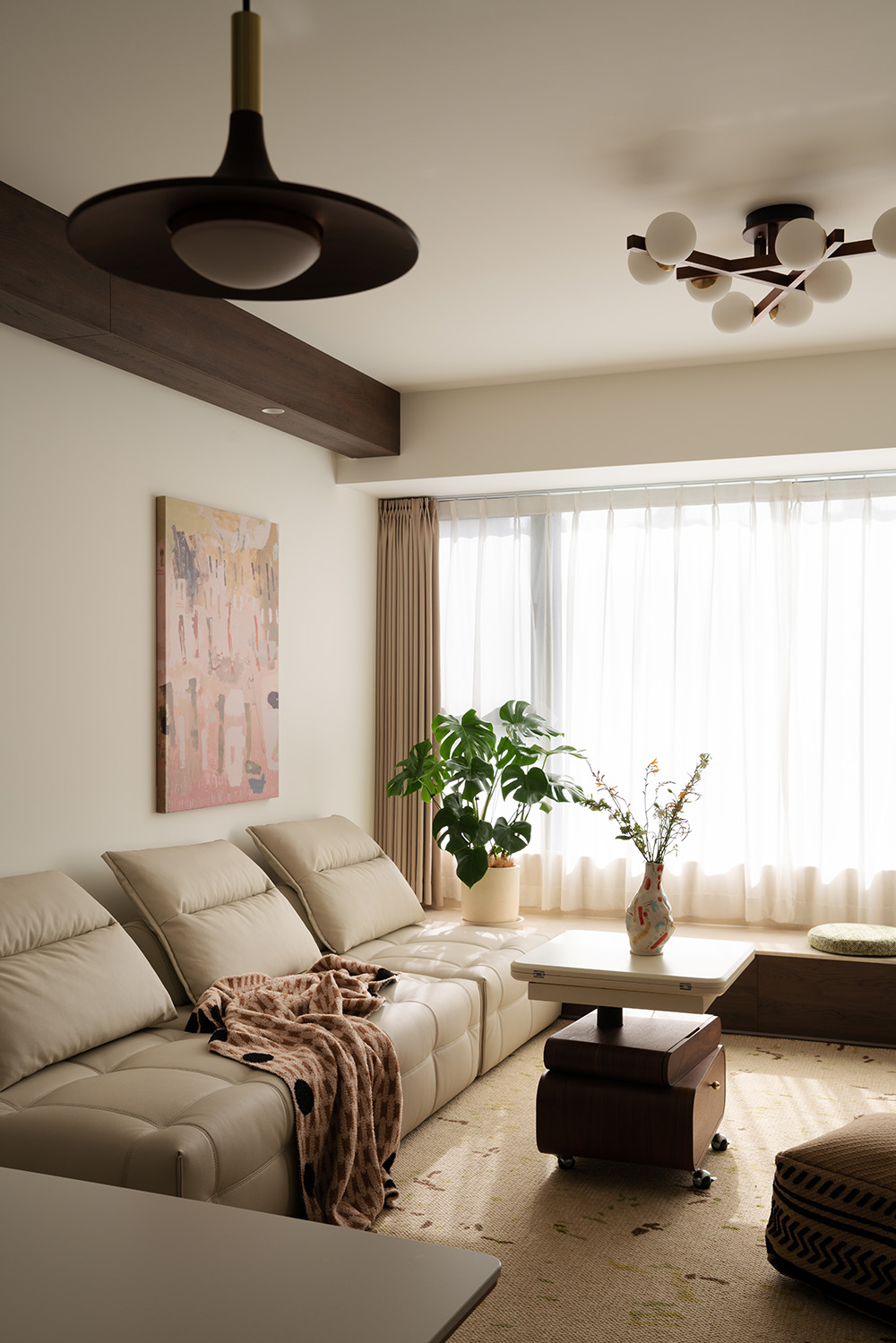 Modern living room with beige leather sectional sofa, warm neutral walls, and natural light.