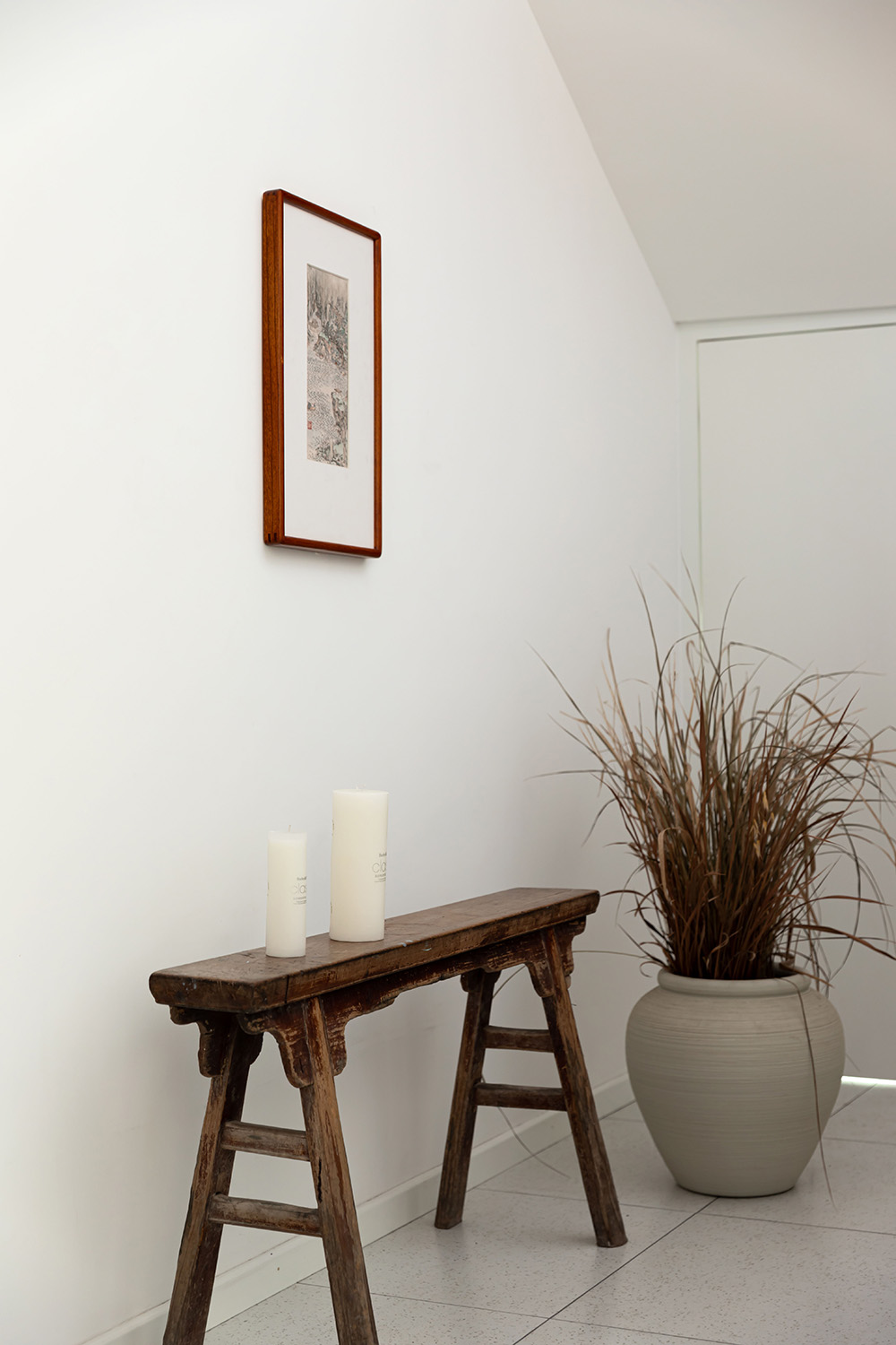 Minimalist styled interior corner in warm wood and ceramic tones with simple decor pieces.