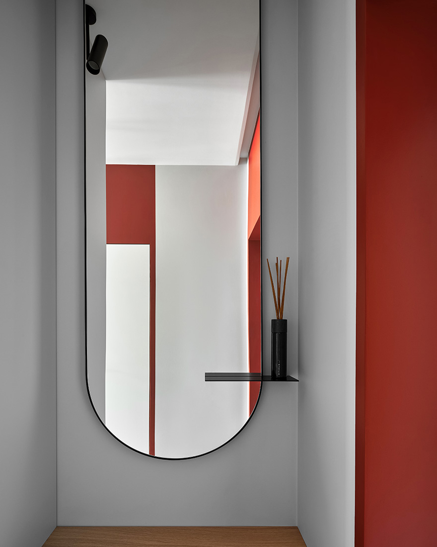 Modern entryway with a mirror, sculptural lighting, and a calm neutral palette.