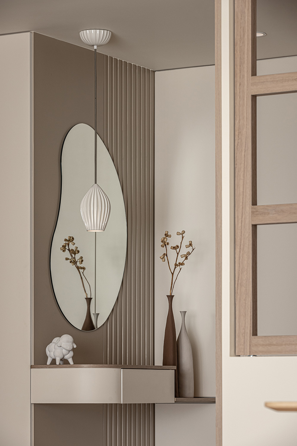 Narrow scandinavian entryway with a large frameless mirror and slim console in neutral tones.