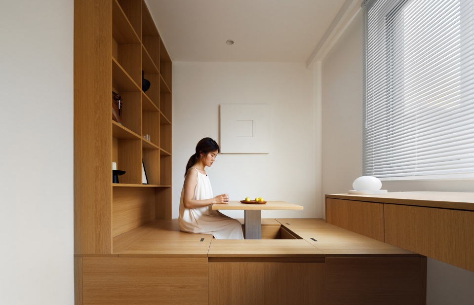 Modern japandi interior with desk positioned toward a window, warm wood tones and soft natural lighting.