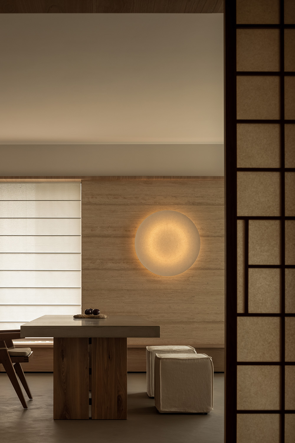 Minimalist interior with light wood surfaces, concrete accents, and fabric textures in a neutral warm palette.