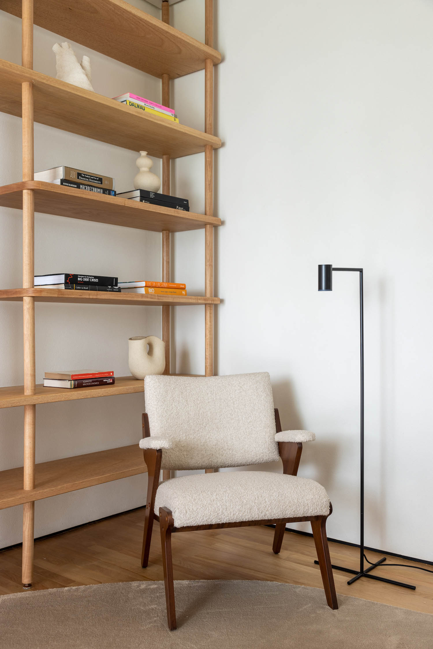 Compact mid-century study space with wood and fabric furnishings, suited to a small-apartment reading corner.