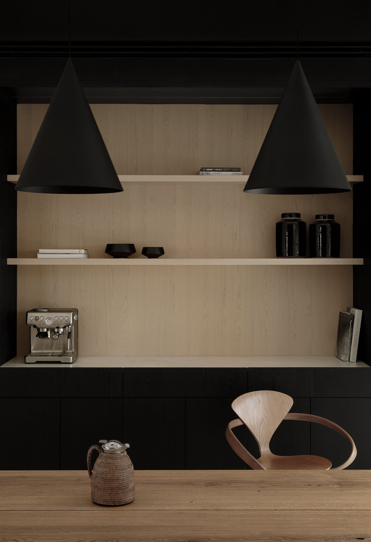 Small warm-minimalist home office nook with a wood desk and black metal accents, ideal for a cloffice conversion.