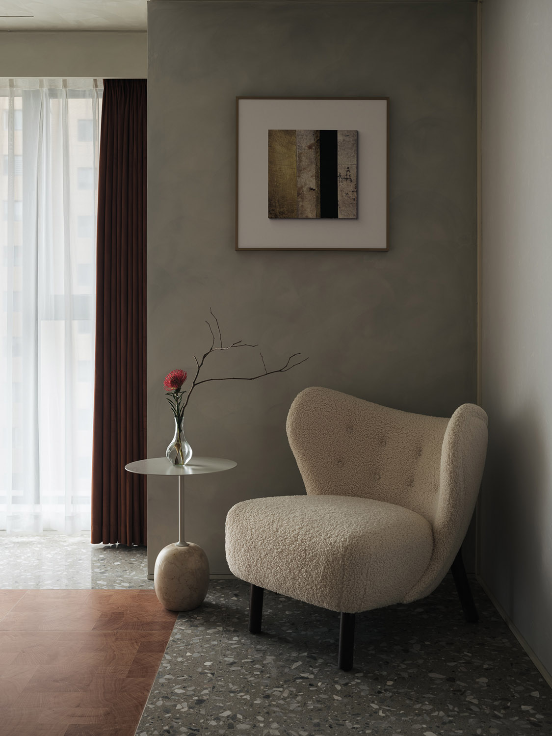 Minimalist living room with a cushioned armchair, showing supportive upholstery suited to long reading sessions.