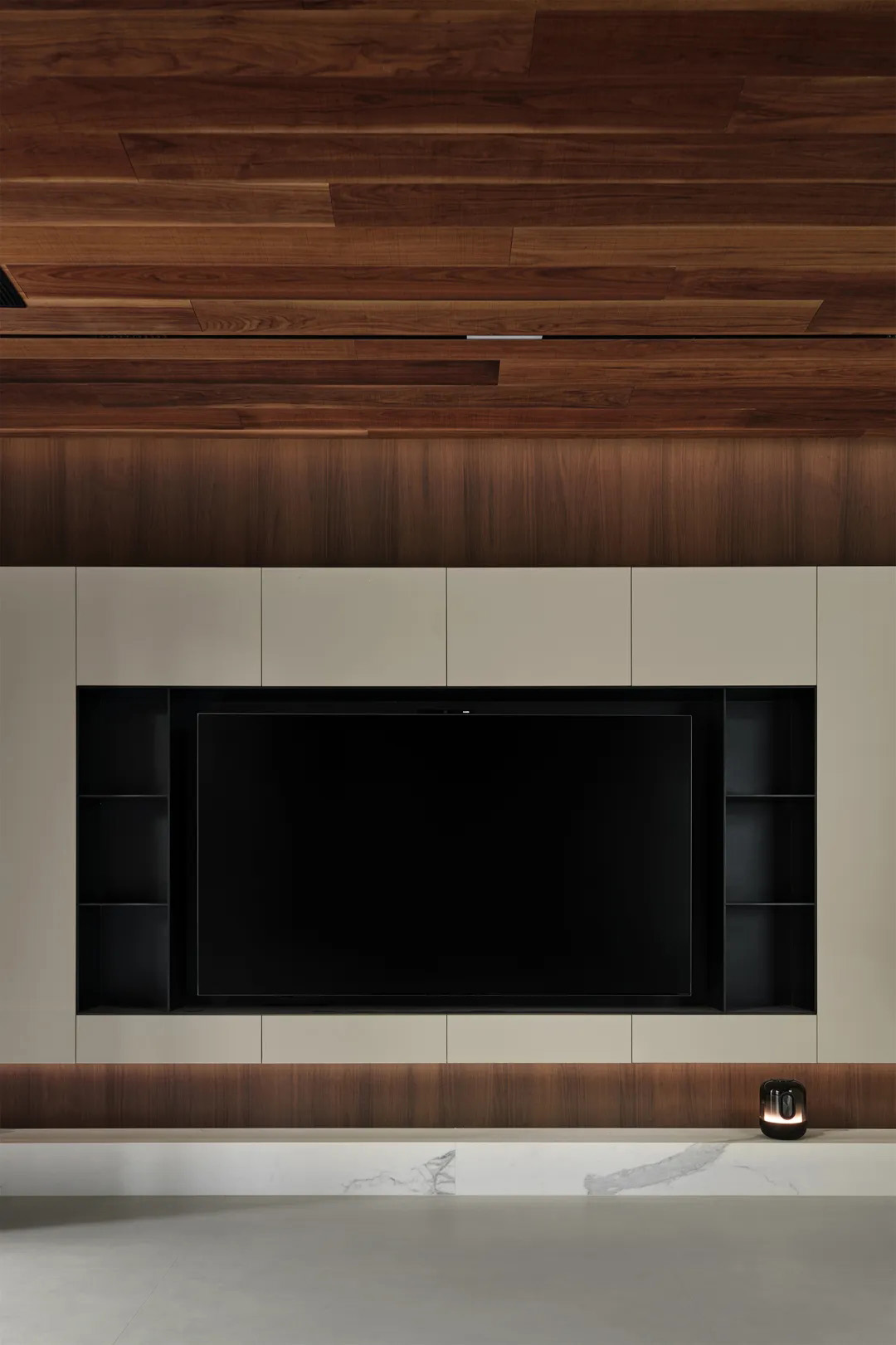 Minimalist living room with warm wood paneling and built-in media wall storage.