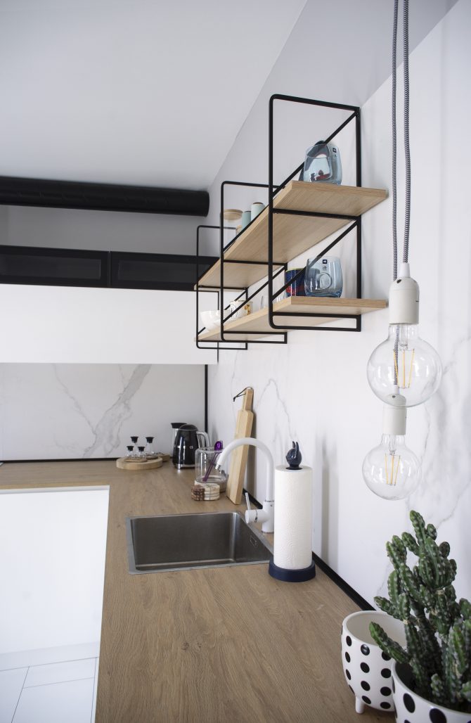 Small apartment wall storage with Scandinavian shelves and warm neutral finishes.