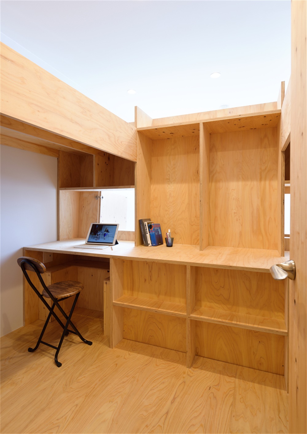 Compact wood home office desk with open shelving, showing built-in style storage in a small footprint.