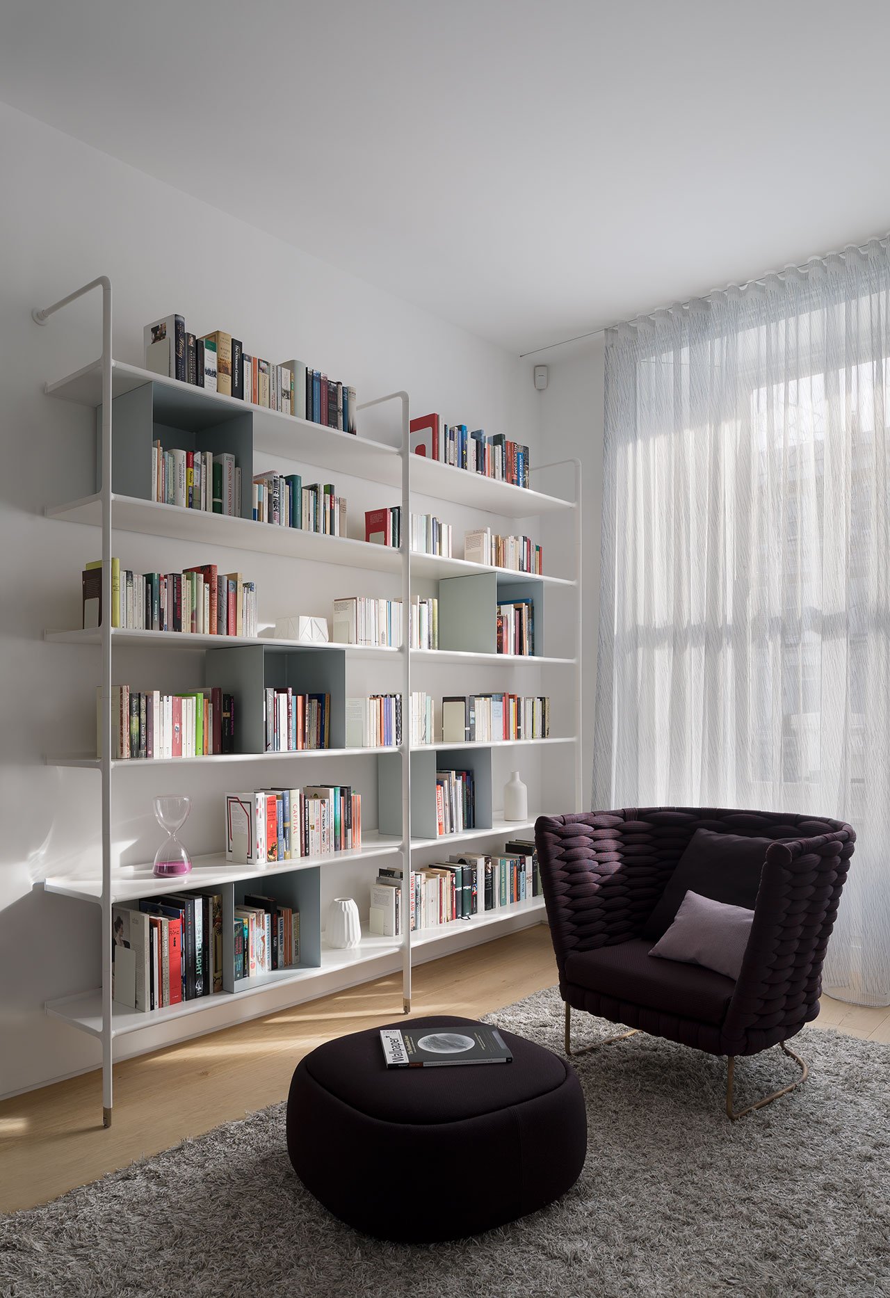 Modern living room with open shelving unit acting as a room divider between lounge and secondary zones.