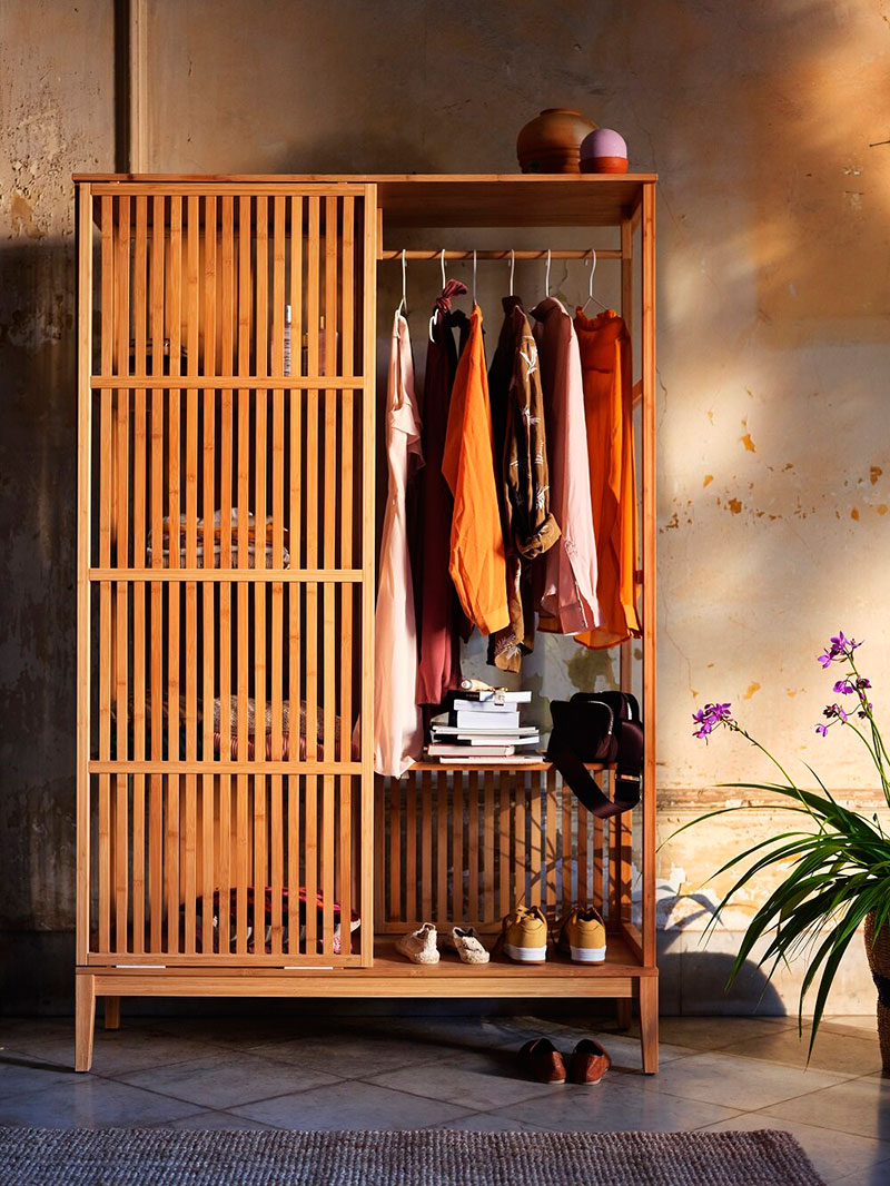 Warm wood wardrobe storage cabinet for minimalist apartment entry organization.