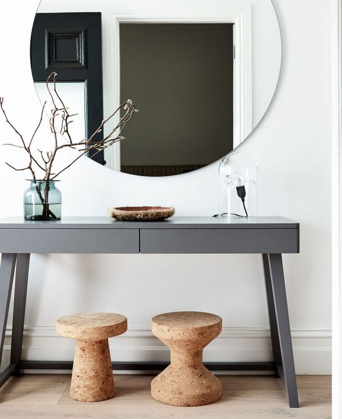 Minimalist entryway with a freestanding stool, plant, and neutral finishes for renter-friendly styling.