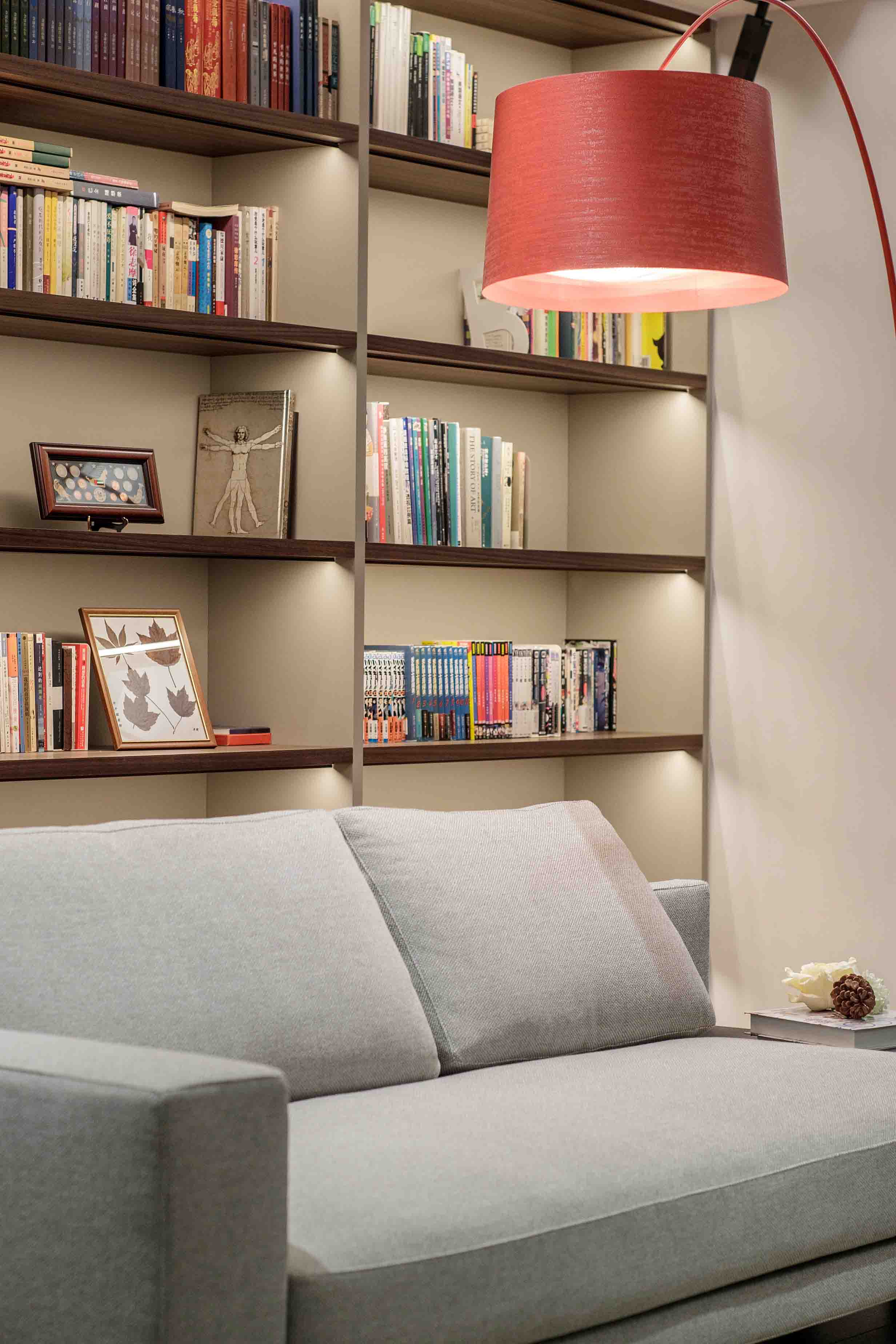 Cozy modern reading nook with a cushioned armchair, warm lighting, and a compact bookshelf tucked into a corner.