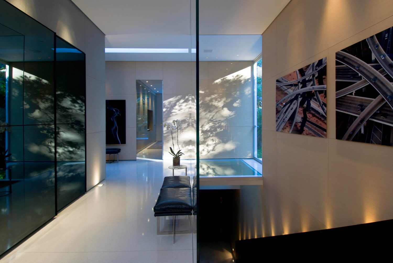 Modern minimalist interior with seamless white walls, frameless doors, and clean ceiling transitions in a warm neutral tone.