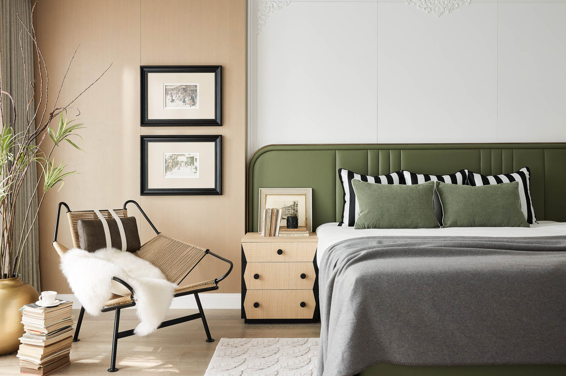 Modern bedroom with a muted green upholstered headboard, natural wood nightstand, and calm earth-tone color palette.