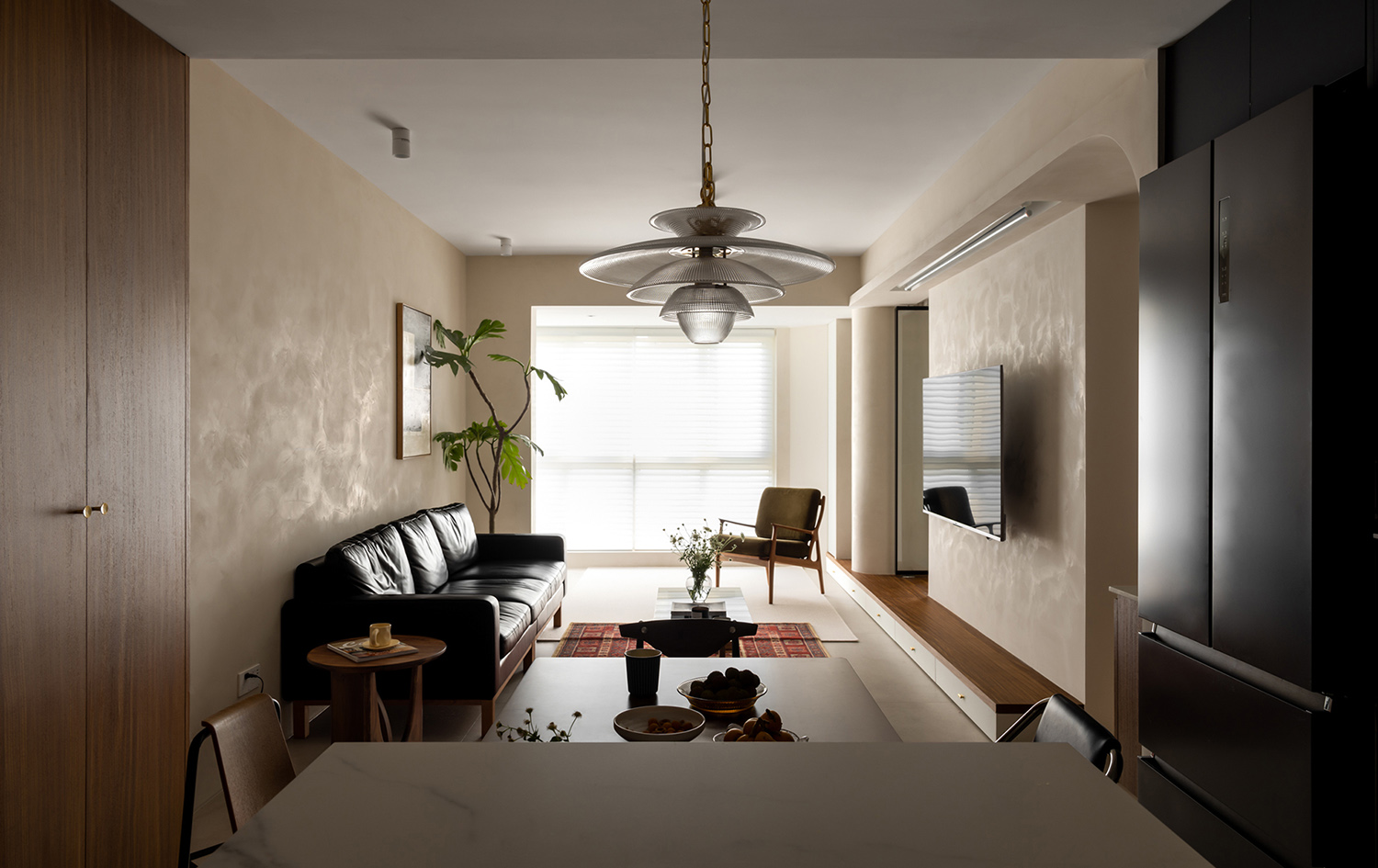 Modern open-plan living and dining space in a compact apartment with neutral tones, maximizing the sense of height and width.