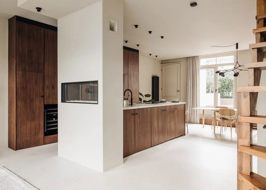 Open-plan modern kitchen with full walnut wood cabinetry, integrated appliances, and a clean neutral palette.