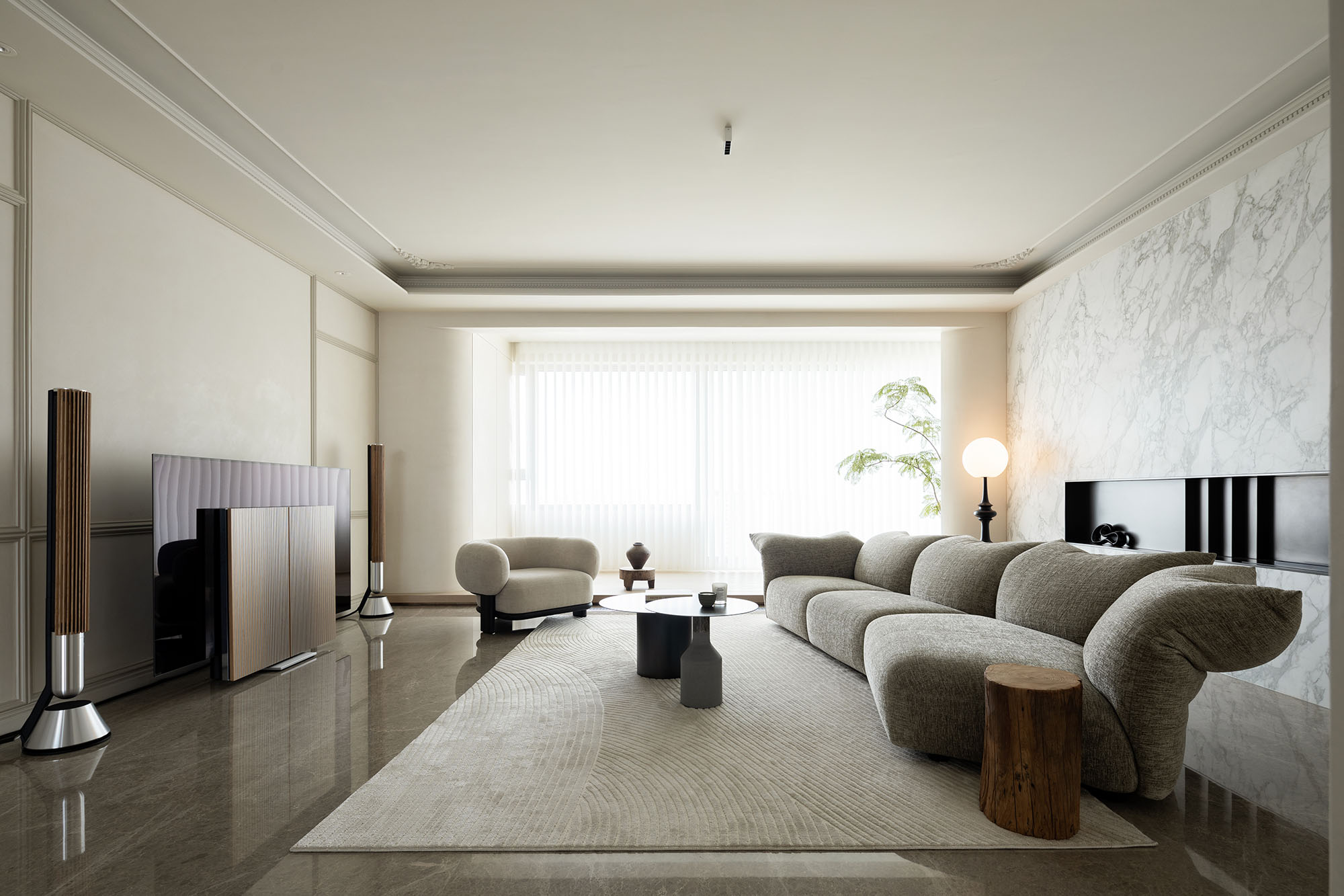Modern living room with sandstone-toned marble accent wall, warm neutral sofa, and minimal wood furnishings.