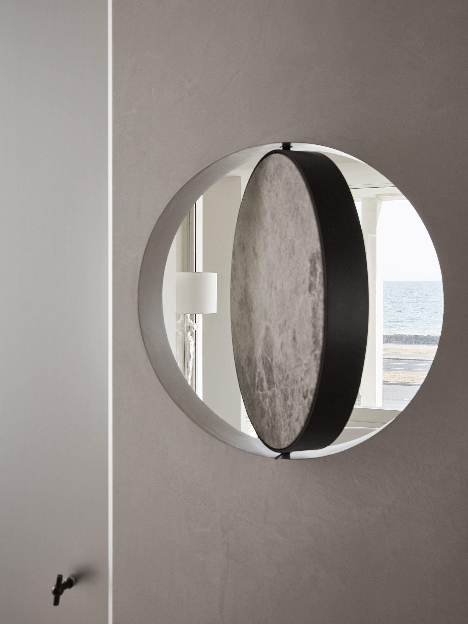 Large arched mirror with a warm metallic frame reflecting soft ambient light.