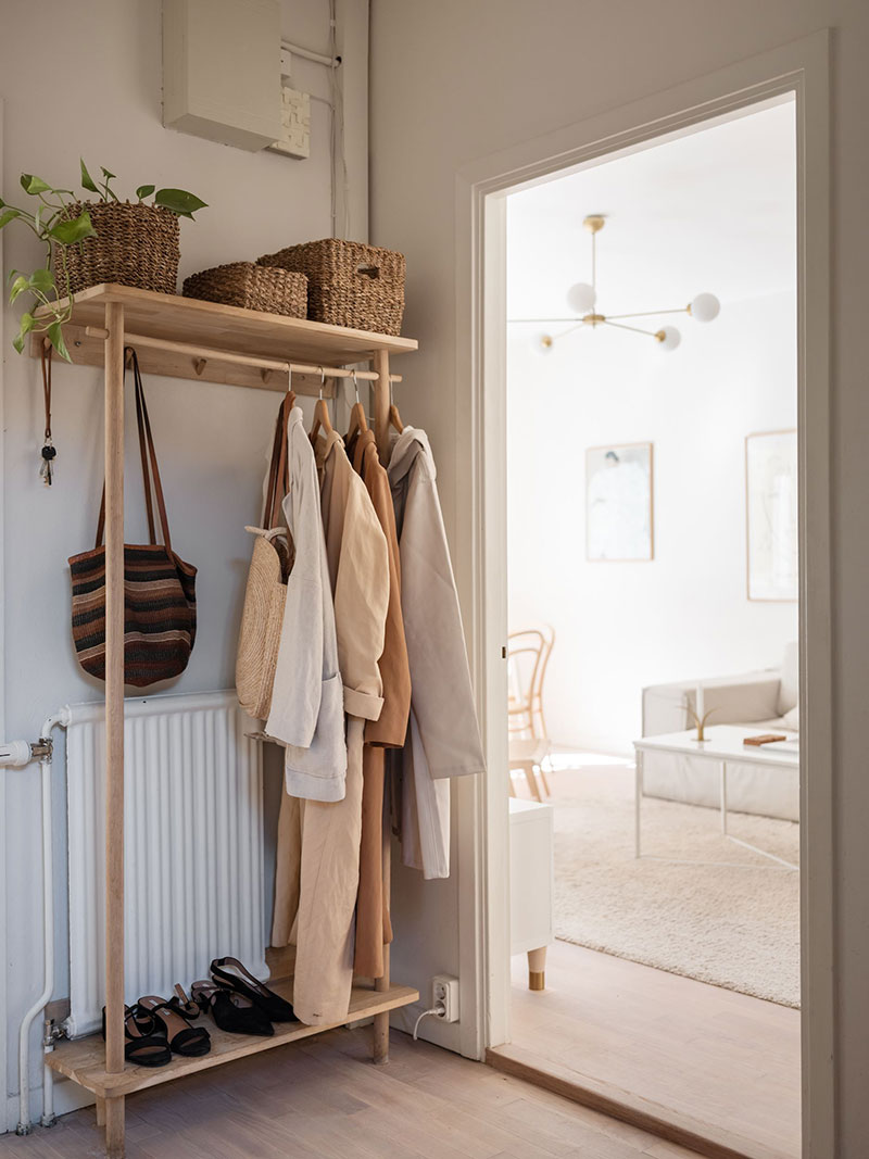 Minimalist wooden storage cabinet for clothing and entryway accessories.