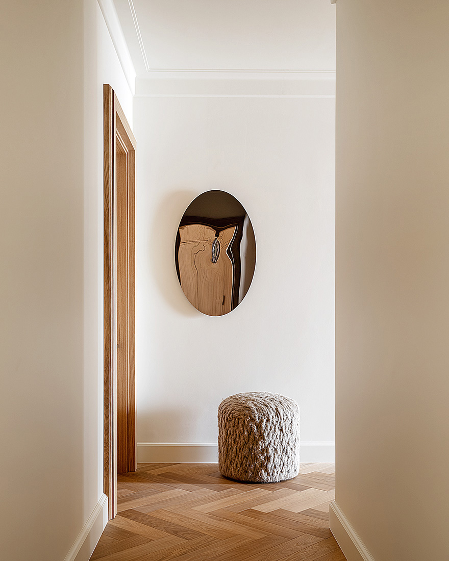 Modern minimalist entryway with warm wood, a clear walkway, and restrained storage details.