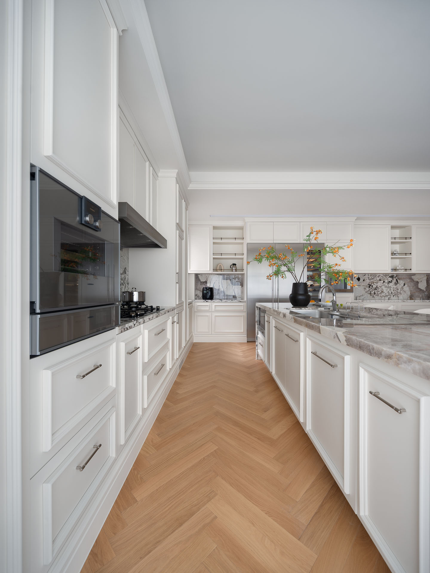 Kitchen with freshly refaced warm white cabinet doors and wooden flooring — showing the visual lift achievable through cabinet refacing on a small budget