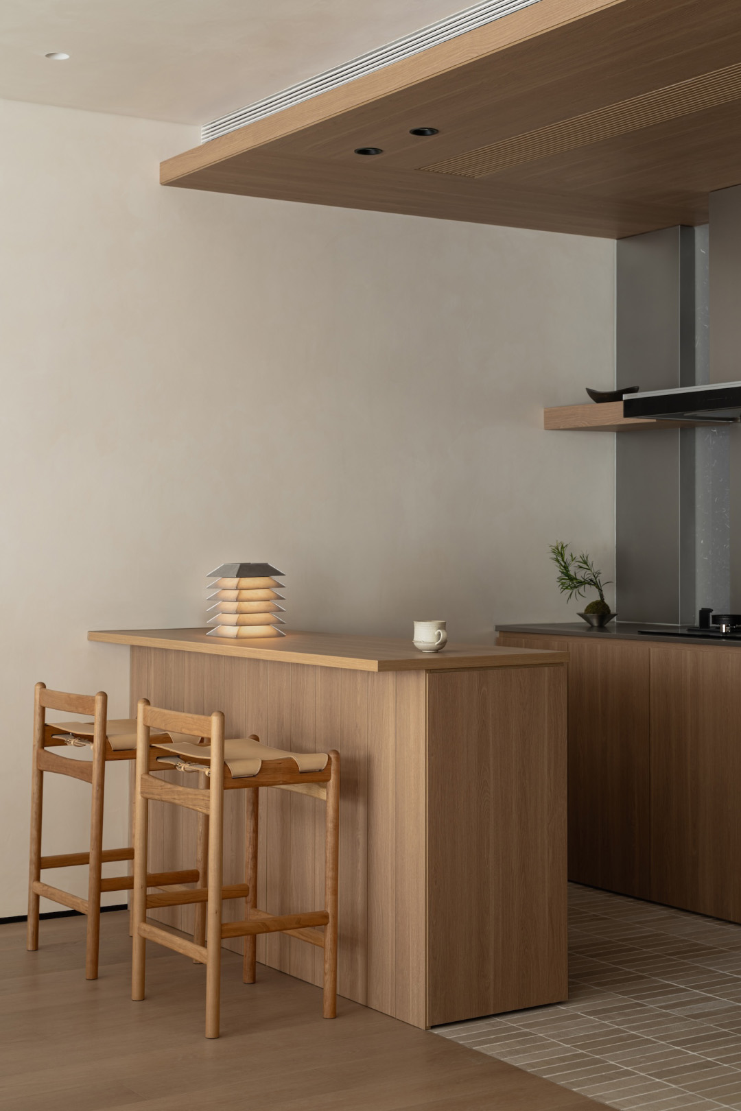 Small modern kitchen with warm wooden cabinets, clean countertops, and minimalist fixtures.