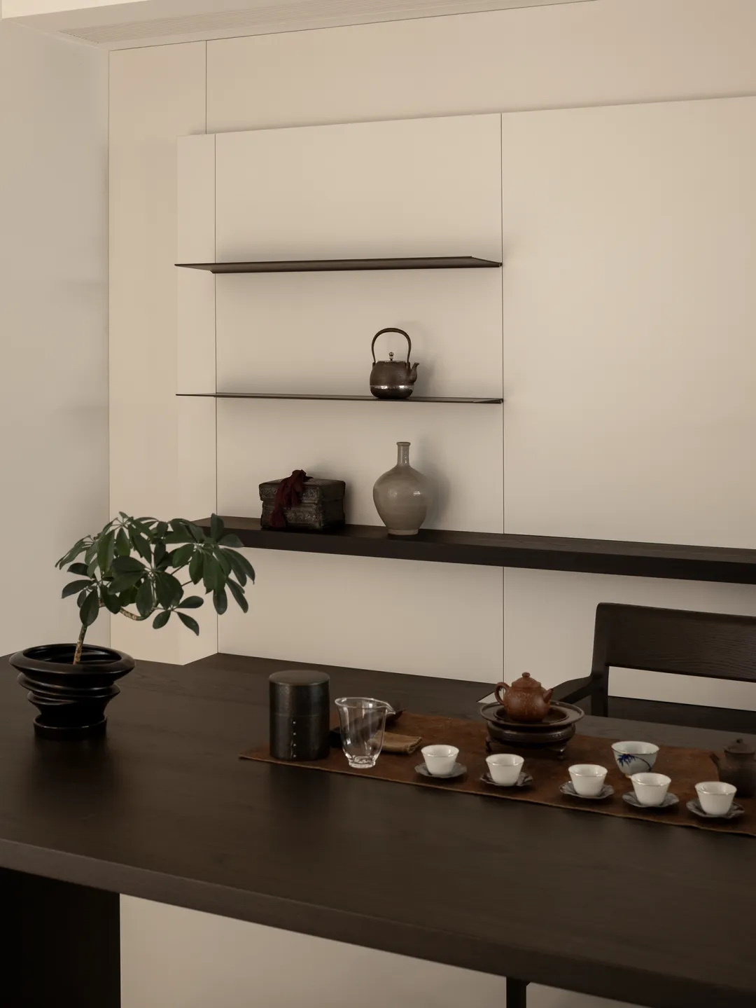 Compact dining area with a solid wood table and chairs, defined as a distinct zone within an open-plan space.