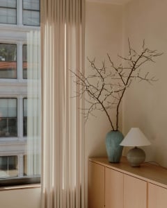A modern, neutral-toned living room featuring minimalist decor and soft lighting.