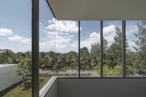 Large glass window overlooking a serene landscape with trees and sky.