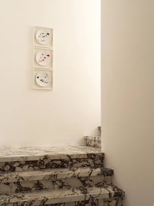 Modern staircase with marble steps and a wall art display.
