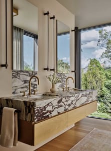 Modern bathroom with marble counter and gold faucets