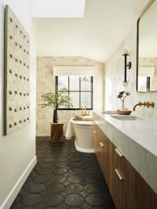 A modern bathroom featuring a tile floor, freestanding bathtub, and marble countertop.
