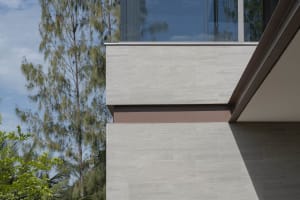 Modern home exterior featuring a tile wall and large windows.