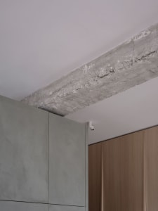 Modern kitchen interior with concrete walls, white cabinets, and minimalist design